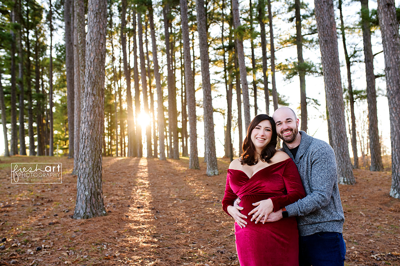 Mom sitting in a chair in a grassy, wooded setting playfully holding her baby girl up over her head - Fresh Art Photography - Preimere Photographer in St Louis